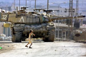 palestinian child throwing rock at israeli tank photo by musa AL SHAER e1481141346313